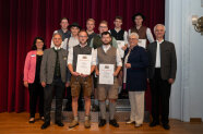 Gruppenfoto Menschen in Trachtenmode vor rotem Vorhang